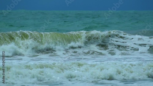 Waves in the raging sea in slow motion, in the background gloomy sky