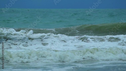 Waves in the raging sea in slow motion, in the background gloomy sky