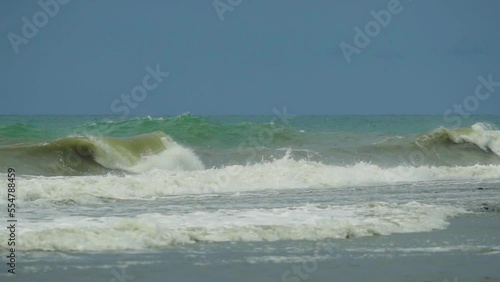Waves in the raging sea in slow motion, in the background gloomy sky