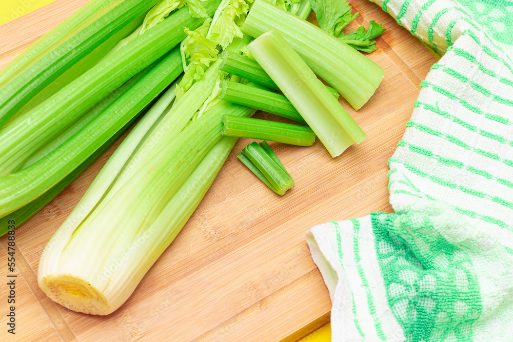 Fresh Celery Stem and Chopped Celery Sticks on Wooden Cutting Board. Vegan and Vegetarian Culture. Raw Food. Healthy Diet with Negative Calorie Content. Slimming Food Fresh Celery Stem and Chopped Celery Sticks on Wooden Cutting Board. Vegan and Vegetarian Culture. Raw Food. Healthy Diet with Negative Calorie Content. Slimming Food