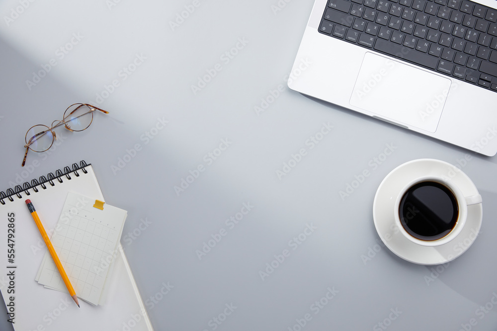 top view of simple gray desk and office supplies with natural window lights. copy space top view of simple gray desk and office supplies with natural window lights. copy space