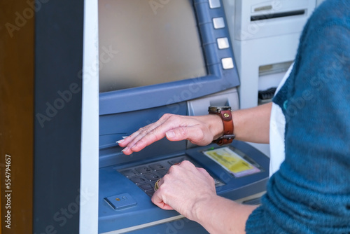 Person enters password while using ATM close-up