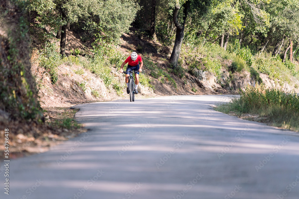 unrecognizable cyclist training hard with his mountain bike on a forest road, concept of freedom and sport in nature, copy space for text unrecognizable cyclist training hard with his mountain bike on a forest road, concept of freedom and sport in nature, copy space for text