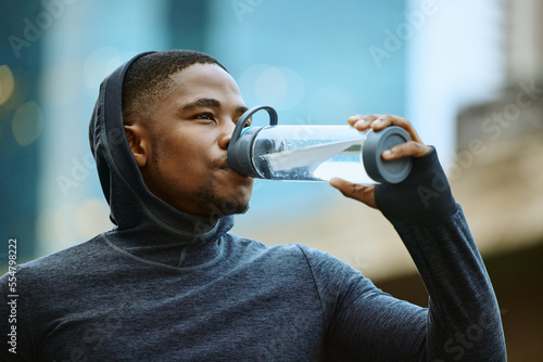 Fitness, drinking water or black man face for exercise, cardio training or running goal. Tired runner, sports or athlete man with water bottle for wellness marathon, city race workout or thirst