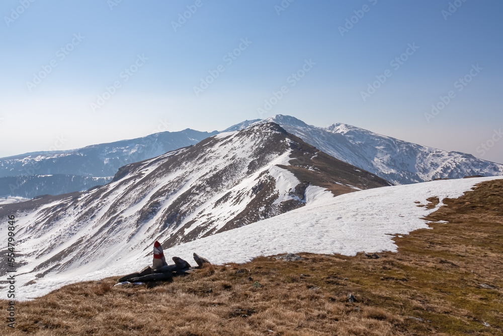 Snow covered alpine pasture with panoramic view on snow capped mountain peak Zirbitzkogel and Kreiskogel in Seetal Alps, Styria, Austria, Europe. Hiking trail Central Alps in winter on sunny day