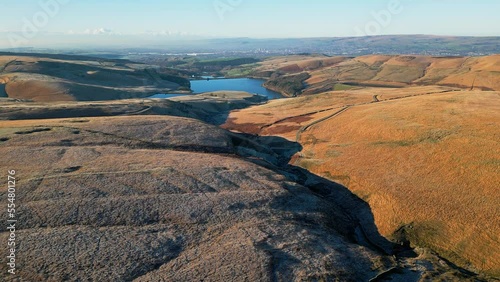 Winter drone footage of Saddleworth Moor, England. Looking across the goldem moorland landscape towards Norman Hill Reservoir, Piethome, and Kitcliff Reservoir near Greater Manchester. photo