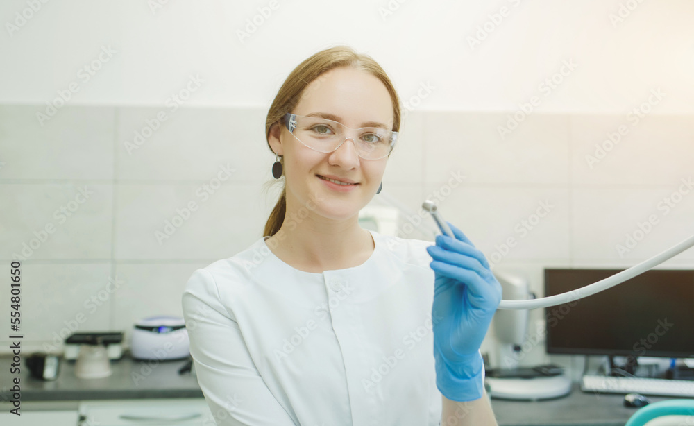 a woman dentist in a white coat a woman dentist in a white coat