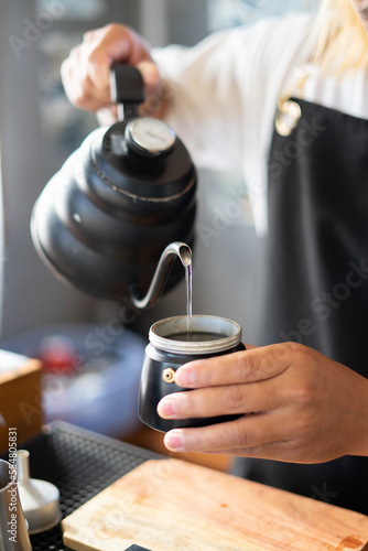 Baristas prepare hot coffee beans in cup pot. to make coffee for steam. Coffee shop concept. in cafe shop for drink small business