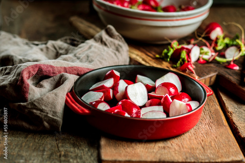 Red radishes in casserole dish at table photo