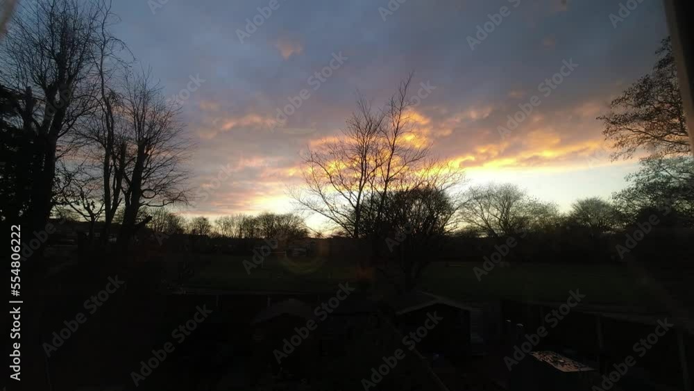 Fiery red sunset clouds passing silhouette autumn garden trees time lapse Fiery red sunset clouds passing silhouette autumn garden trees time lapse