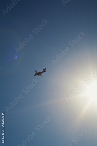 Airplane flying across blue sky landscape photo. Beautiful nature scenery photography with atmosphere on background. Idyllic scene. High quality picture for wallpaper, travel blog, magazine, article © Gypsy On The Road