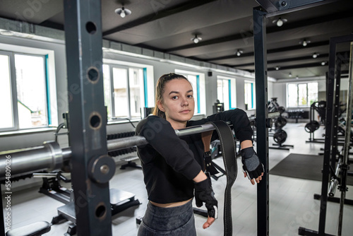 girl practices strength exercises with a new simulator in a spacious gym to lose extra pounds.