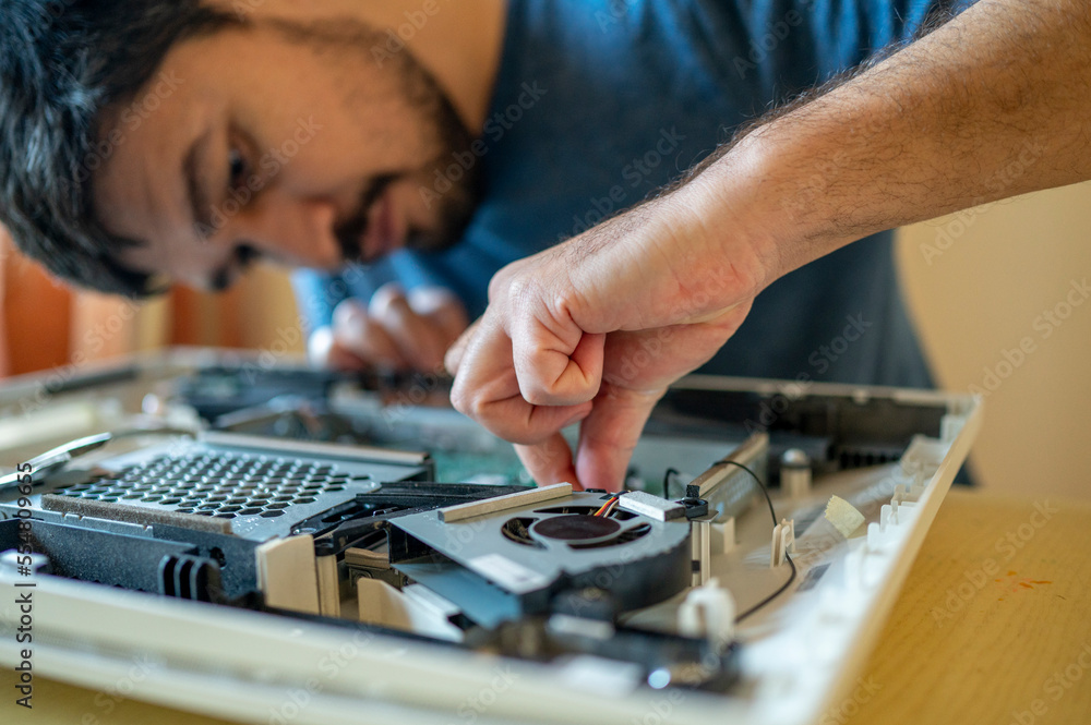 Man repairing mother board of computer on table at home Man repairing mother board of computer on table at home