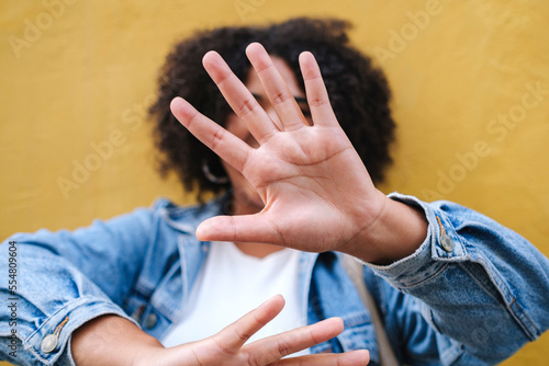 Woman showing stop gesture in front of wall