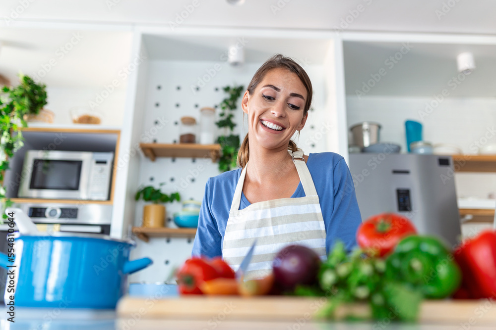 Beautiful young woman stand at modern kitchen chop vegetables prepare fresh vegetable salad for dinner or lunch, young woman cooking at home make breakfast follow healthy diet, vegetarian concept Beautiful young woman stand at modern kitchen chop vegetables prepare fresh vegetable salad for dinner or lunch, young woman cooking at home make breakfast follow healthy diet, vegetarian concept