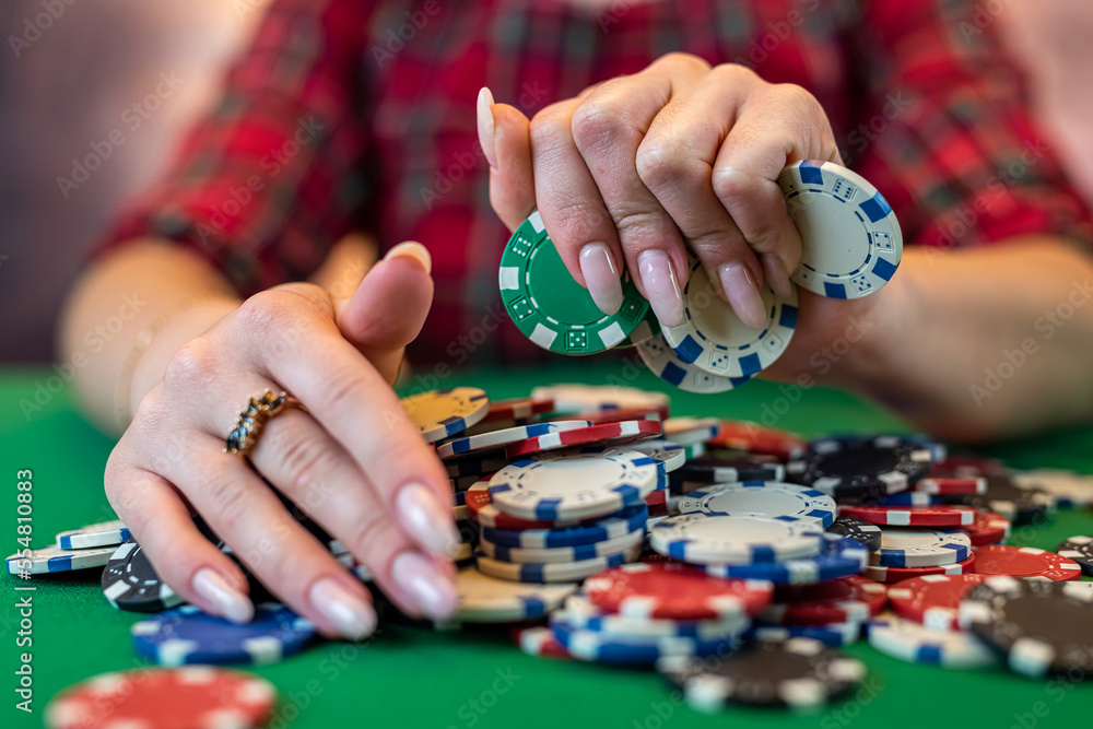 woman in a casino with many chips that she wraps up after a big win in poker. woman in a casino with many chips that she wraps up after a big win in poker.