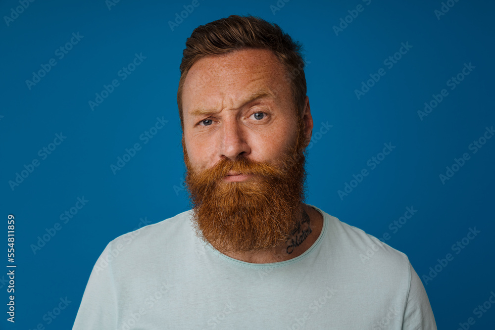 Ginger puzzled man with beard frowning and looking at camera Ginger puzzled man with beard frowning and looking at camera