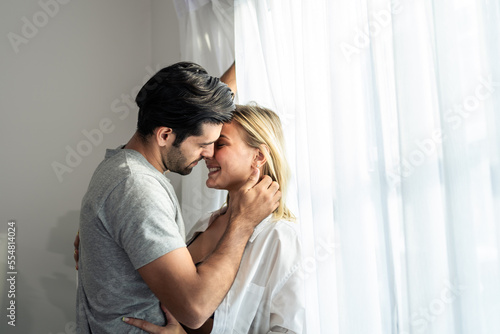 Caucasian young couple spend free leisure time together in living room.