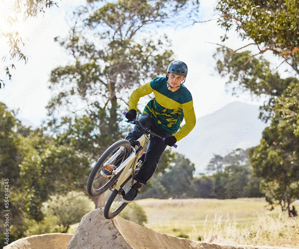 Obraz premium Mountain bike man, air ramp and outdoor with helmet, extreme sport and focus for fitness, speed and training. Bmx bicycle. sports expert and fast jump in nature, trail and cycling for competition