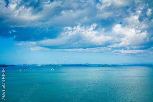Colourful sailing boats scattered over calm waters of Auckland Harbour on a beautiful winter day. North Island, New Zealand