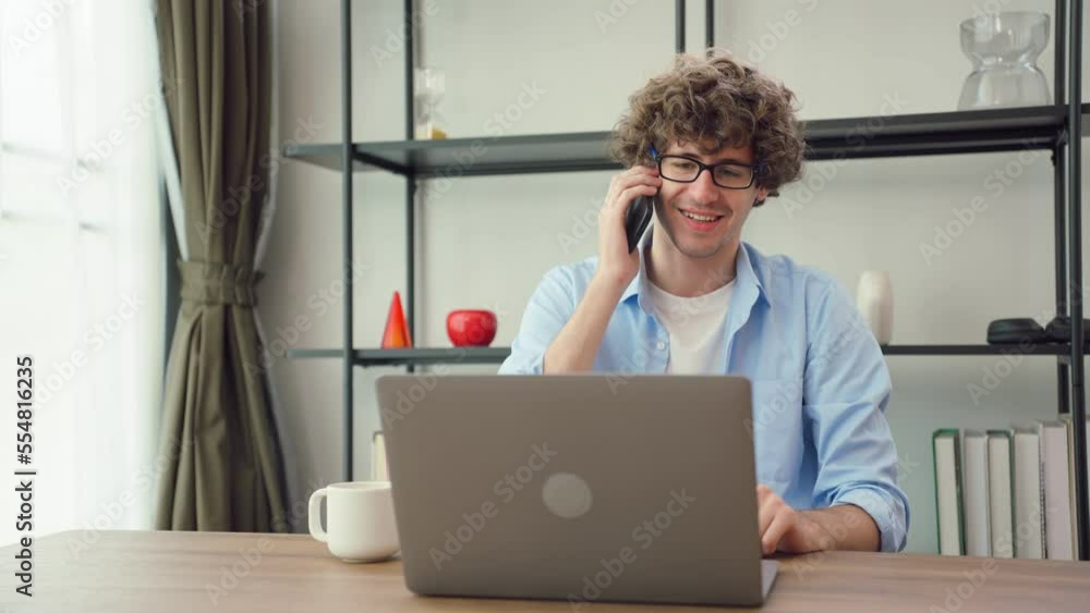 Caucasian young businessman typing on computer while working from home Caucasian young businessman typing on computer while working from home