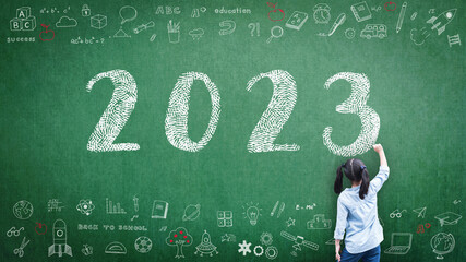 2023 Happy new year school class academic calendar with student kid's hand drawing greeting on teacher's green chalkboard for educational celebration, back to school, STEM education classroom schedule