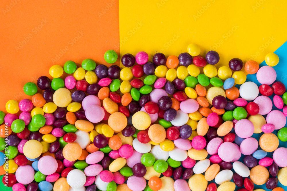 Obraz premium Skittles candy on the colorful table, colorful sweet candy