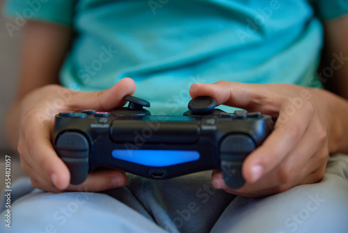 Boy playing video game at home, Online entertainment and leisure activity