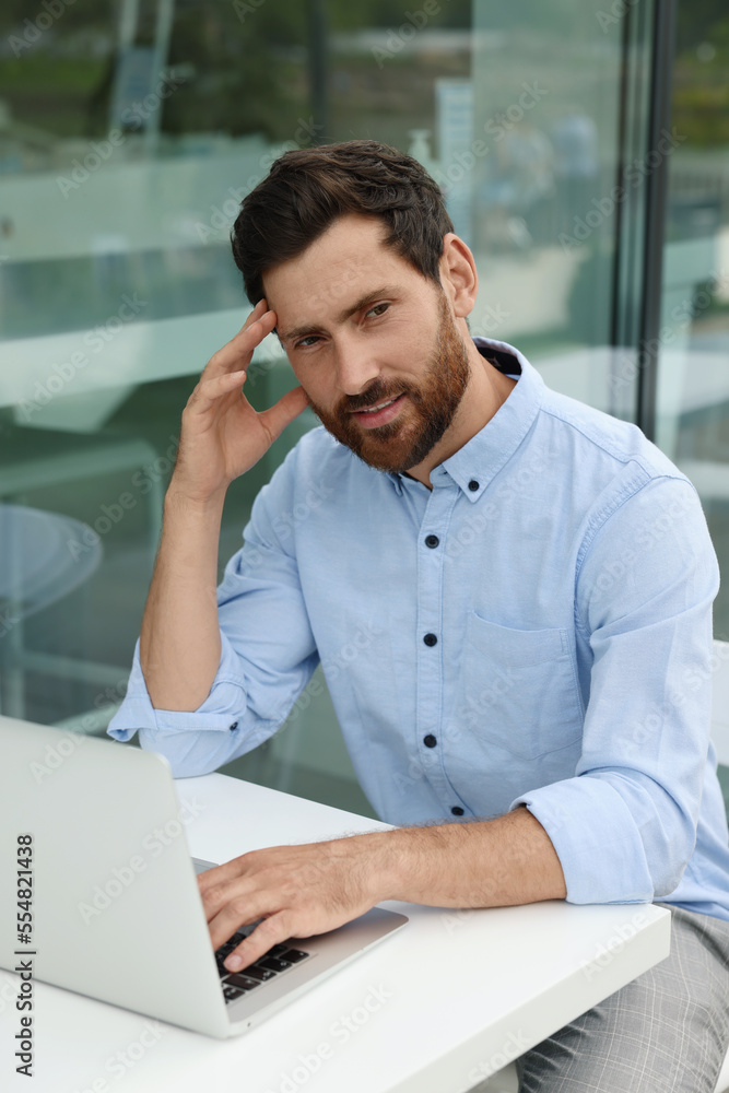 Portrait of handsome bearded man with laptop in outdoor cafe Portrait of handsome bearded man with laptop in outdoor cafe