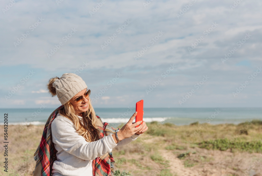 traveler woman taking a selfie on the beach with mobile phone