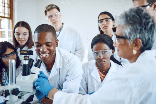 Education  science and teacher with students using microscope for chemistry  biology and medical research . Medicine  healthcare lab and mentor with university class to study analytics of dna sample