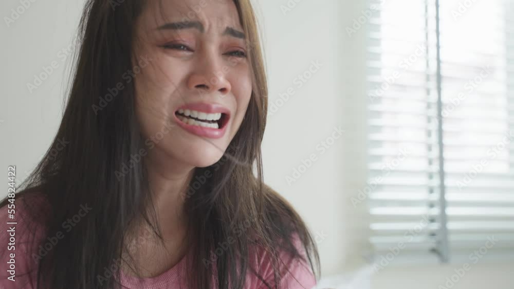 Asian young upset depressed woman sitting alone in living room at home. Asian young upset depressed woman sitting alone in living room at home.