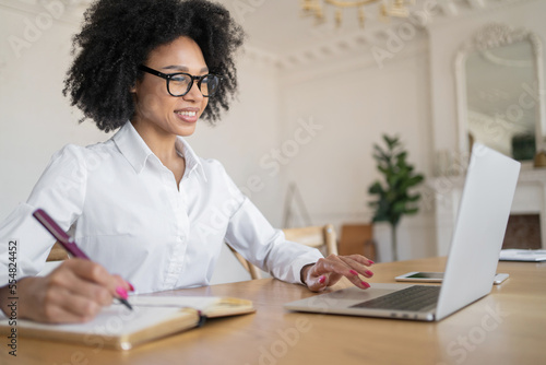 A female student communicates via video link works online in the office uses a laptop