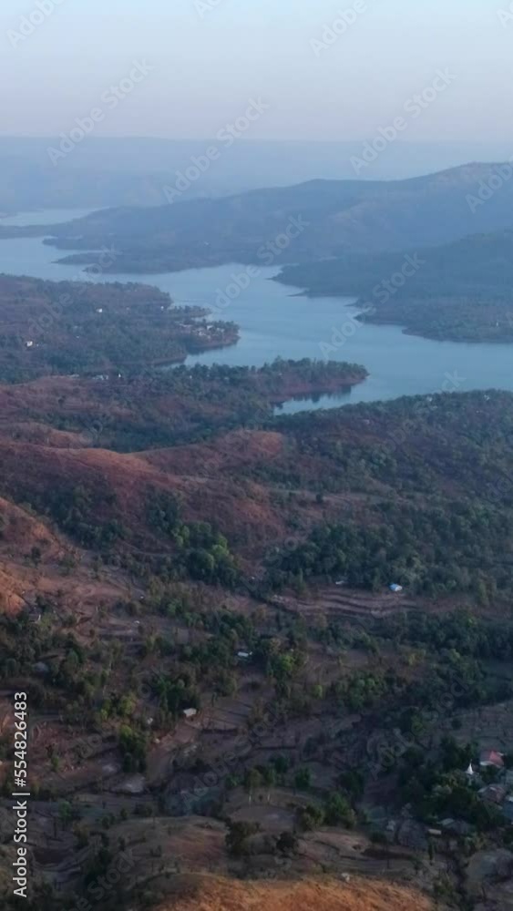 Vertical video of Aerial shot of river running between hills with tropical forest at sunset Vertical video of Aerial shot of river running between hills with tropical forest at sunset