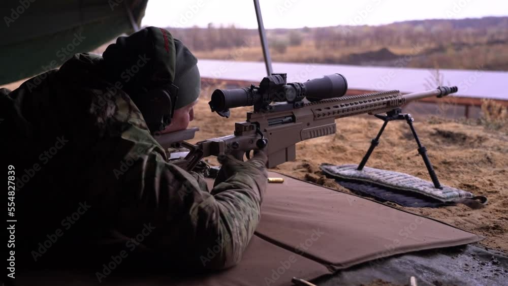 a military man in a prone position shoots a rifle and then reloads the weapon a military man in a prone position shoots a rifle and then reloads the weapon