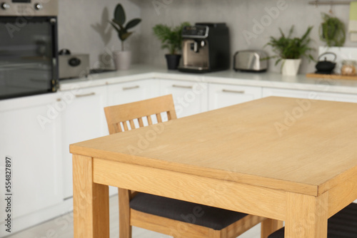 Stylish wooden table with chairs in kitchen. Interior design