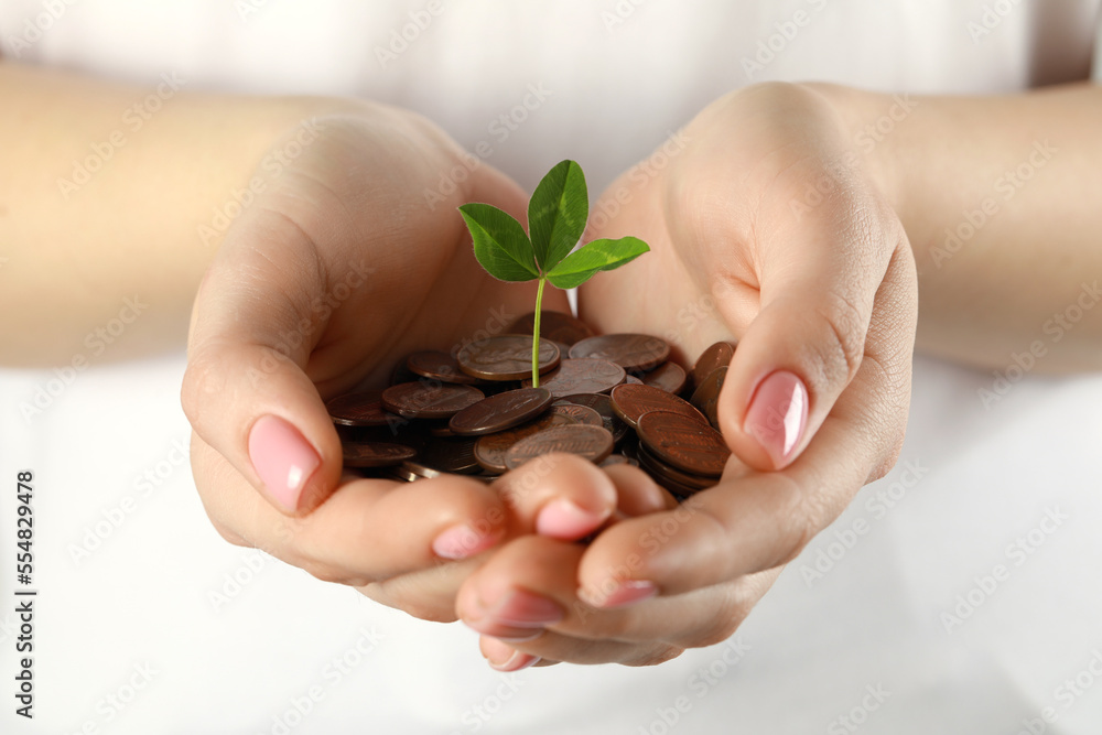 Woman holding many coins with green sprout on white background, closeup. Investment concept Woman holding many coins with green sprout on white background, closeup. Investment concept