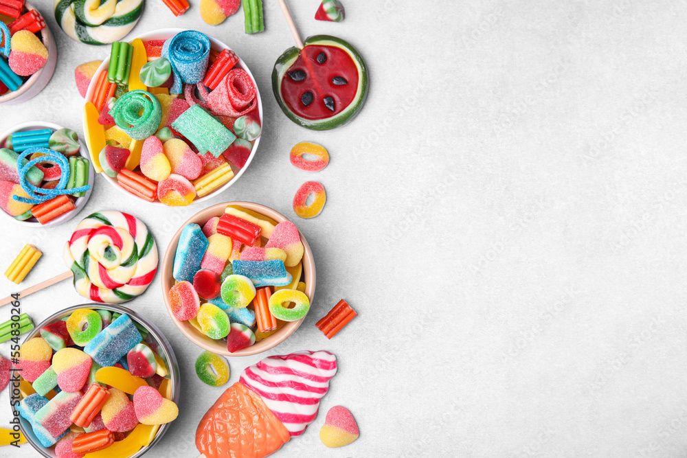 Many tasty colorful jelly candies on white table, flat lay. Space for text