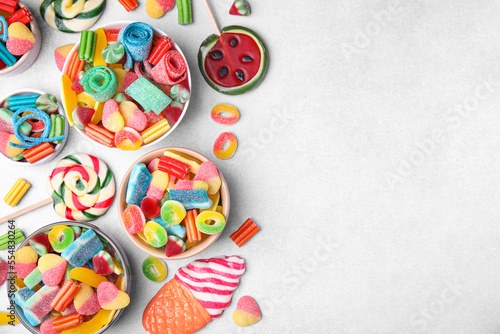 Many tasty colorful jelly candies on white table  flat lay. Space for text