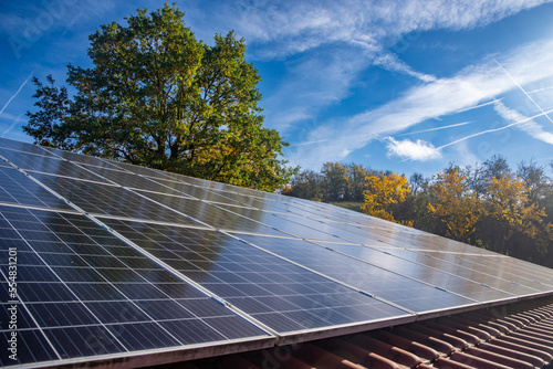 Photovoltaic system on the roof of the house with trees in the background