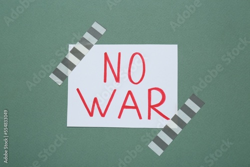 Phrase No War attached with adhesive tape on green background photo