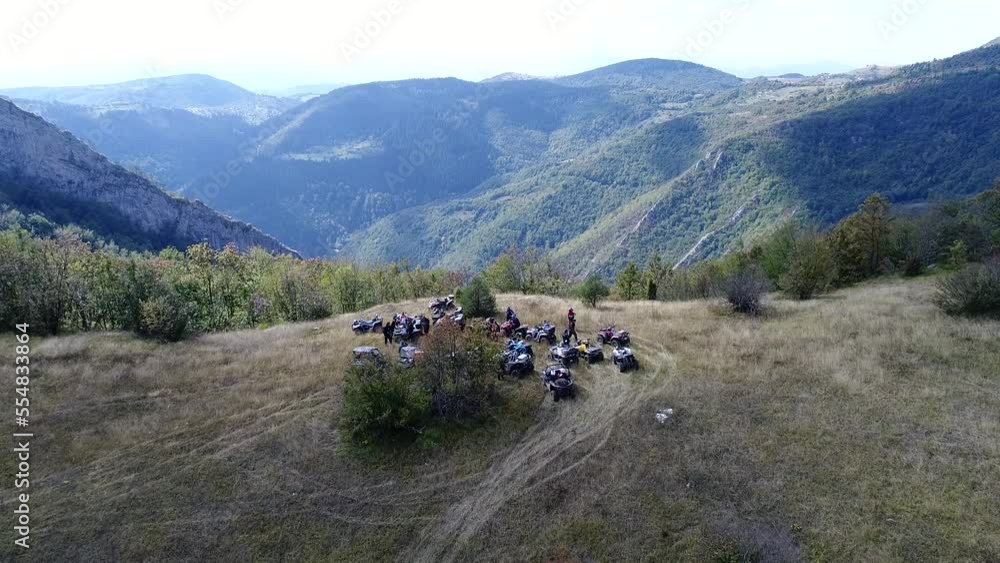 Aerial drone view of ATV quads on a dirt trail in forests. Off-road group team club enthusiasts having fun while driving countryside roads. Aerial drone view of ATV quads on a dirt trail in forests. Off-road group team club enthusiasts having fun while driving countryside roads.