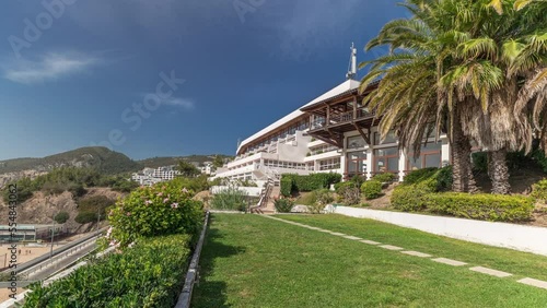 Panorama showing green garden and the coastline of the village of Sesimbra timelapse, in the middle of the Atlantic Ocean. View of the beach and waterfront with lawn from above. Portugal photo