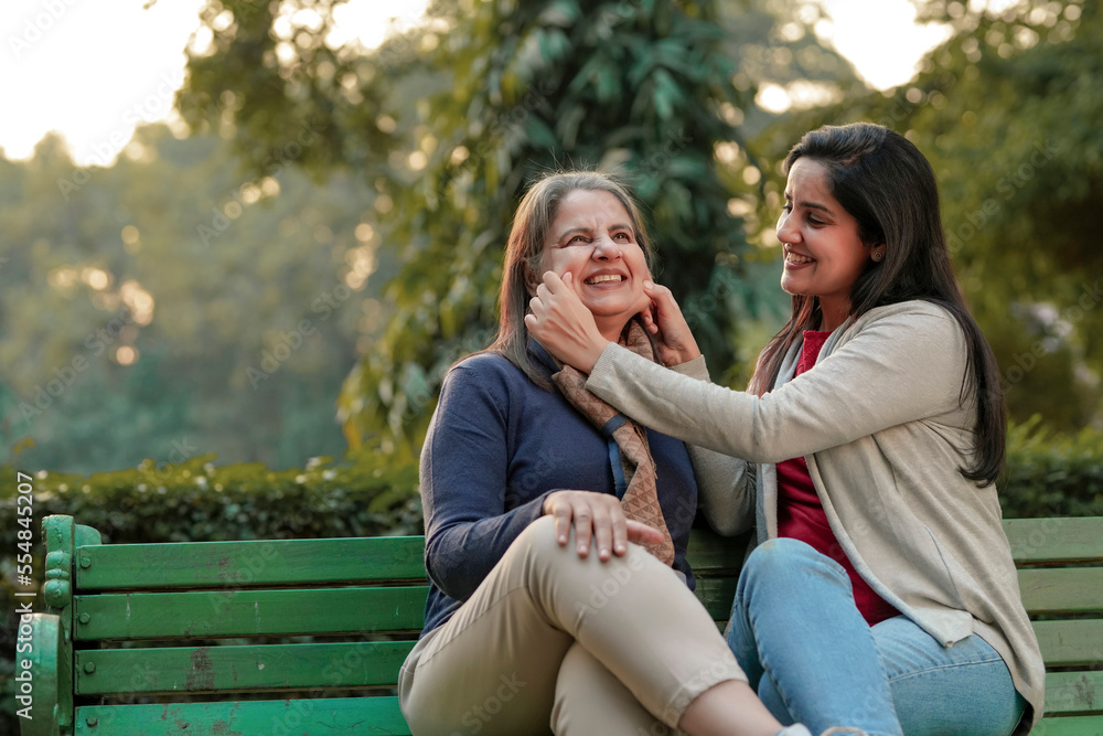 Two indian woman sitting in winter wear and enjoying at park Two indian woman sitting in winter wear and enjoying at park