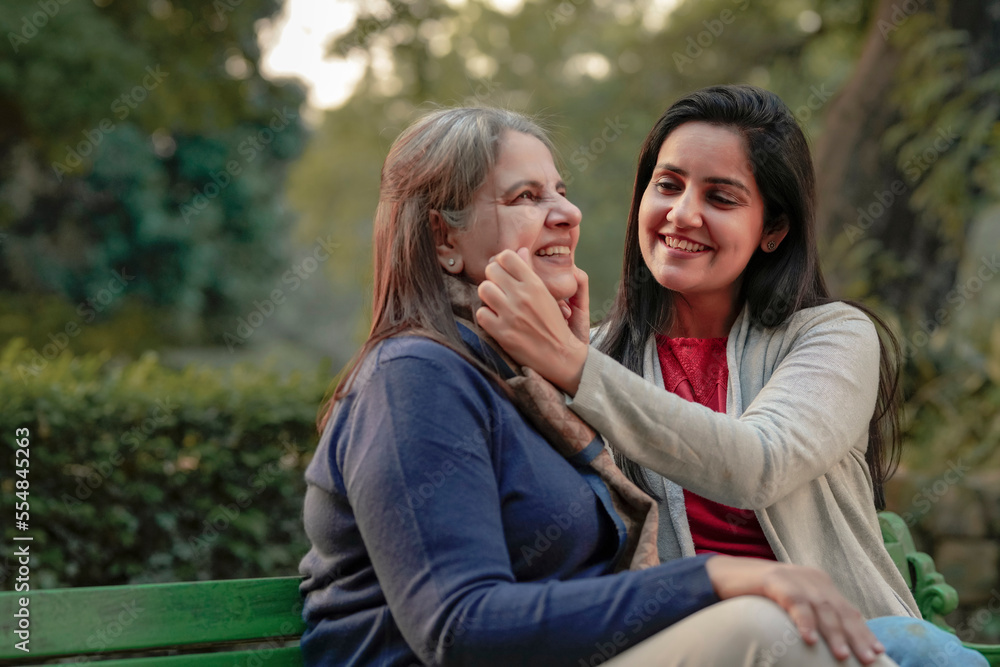 Two indian woman sitting in winter wear and enjoying at park Two indian woman sitting in winter wear and enjoying at park