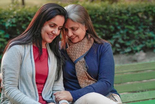 Fotografija Two indian woman sitting at park in winter wear