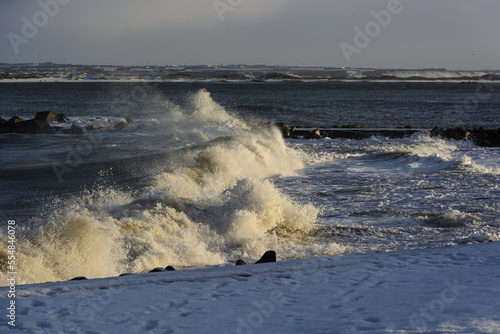 violent steep waves crashing onto a sandy beach during winter. Shot in Denmark photo