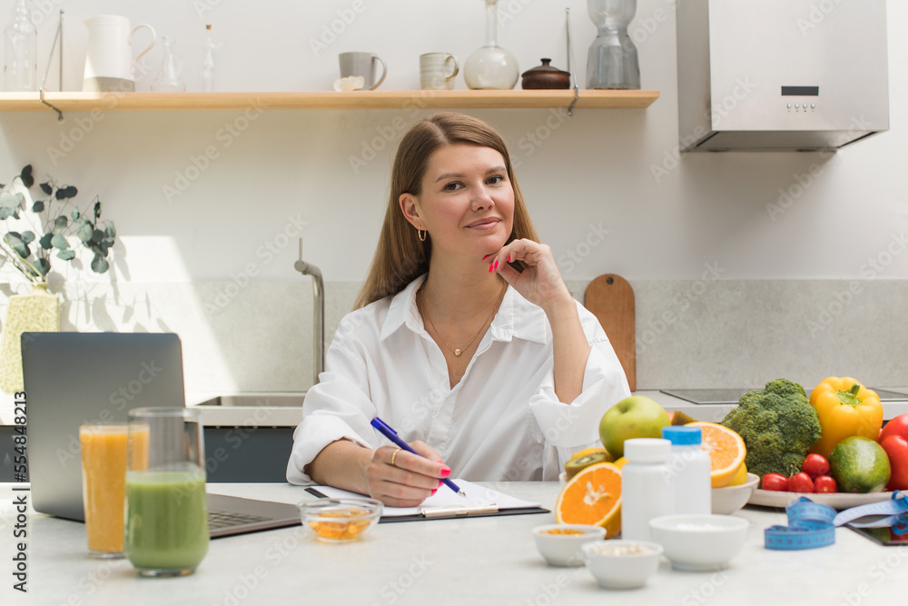 A nutritionist writes an appointment for vitamins and supplements and draws up a nutrition plan A nutritionist writes an appointment for vitamins and supplements and draws up a nutrition plan