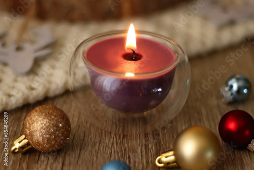 Various Christmas decorations, cup of tea or coffee, sweets, small presents, knitted blanket and candles. Selective focus.