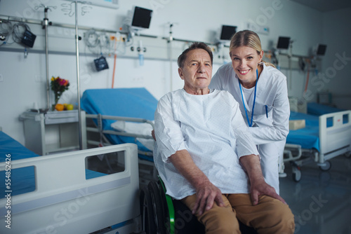 Portrait of happy doctor woman with her patient on wheelchair.